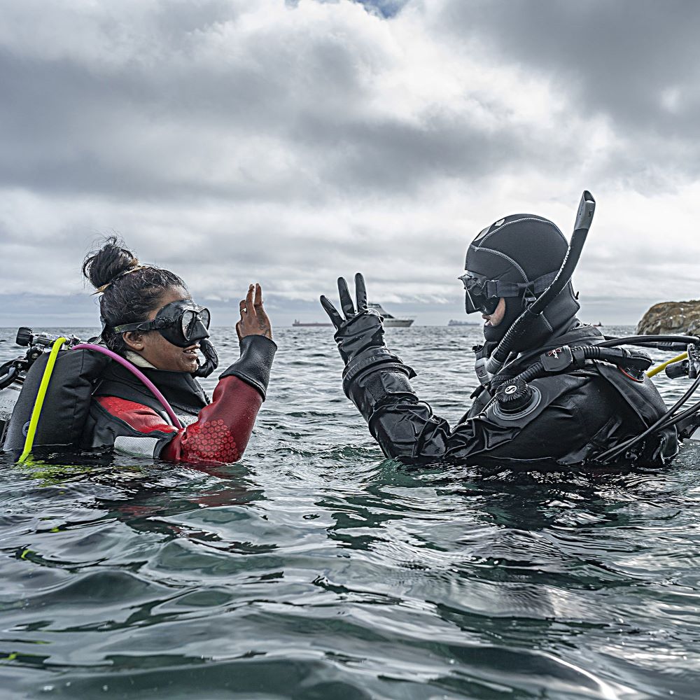 Beginner scuba student listening to instruction poolside