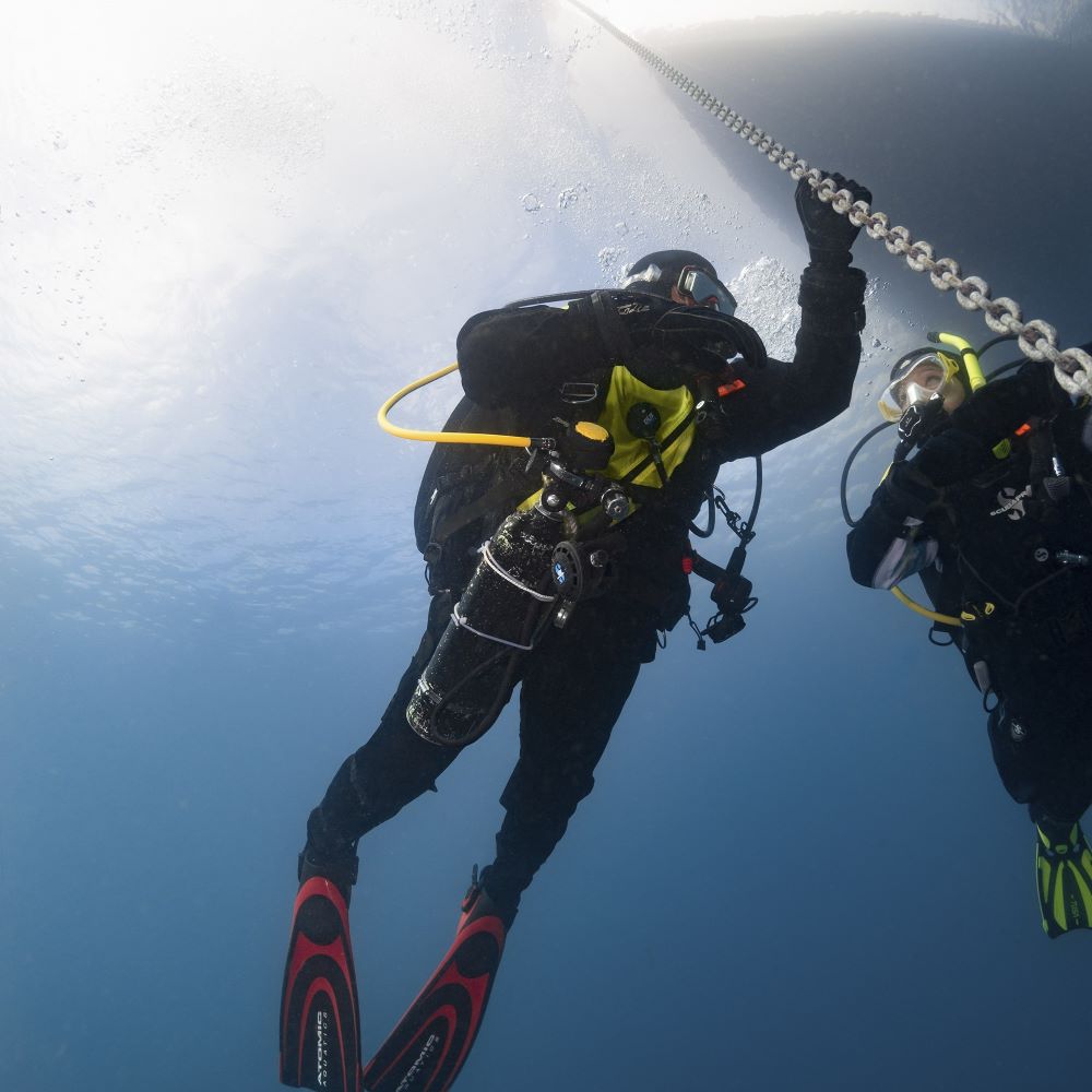 Dive shop team helping new divers with gear