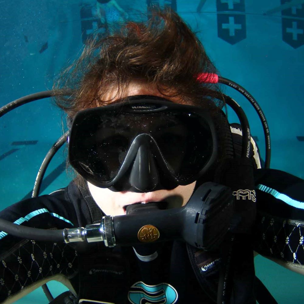 Instructor calmly assisting a new diver underwater